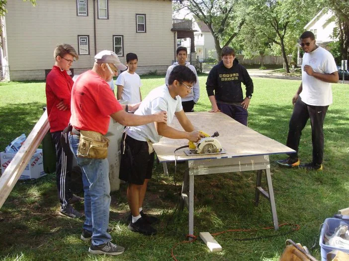 students learning to use a power saw