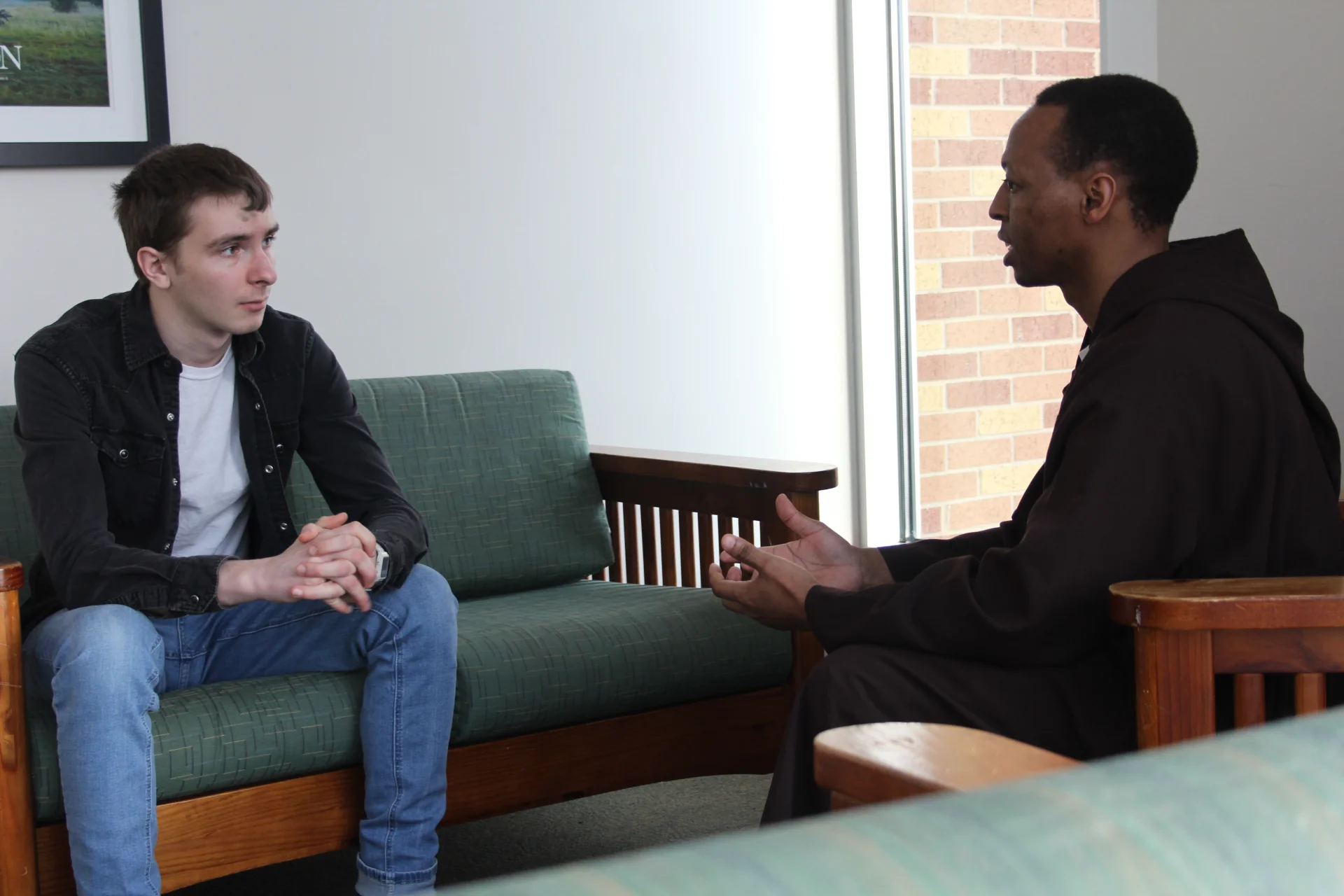 Student speaking with a capuchin priest